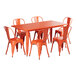 A Lancaster Table & Seating amber orange table and chairs on an outdoor patio.