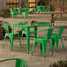 A Lancaster Table & Seating jade green table with four chairs on a stone patio.