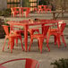 An orange table and chairs on an outdoor patio.