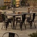 A Lancaster Table & Seating outdoor table and chairs set on a patio.