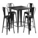 A Lancaster Table & Seating black metal bar table with four black metal barstools.