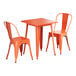 An orange metal Lancaster Table & Seating outdoor table and chairs set.