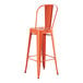 An orange metal bar stool with a backrest.