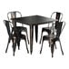 A Lancaster Table & Seating distressed copper table with black metal chairs.