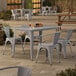 A Lancaster Table & Seating outdoor table with four chairs on a patio.