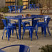 A blue table and chairs on a stone patio.