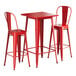 A red square Lancaster Table & Seating bar table with two chairs.