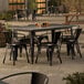 A Lancaster Table & Seating outdoor patio table with 6 black chairs.