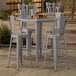 A Lancaster Table & Seating outdoor bar table with 4 chairs.