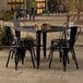 A Lancaster Table & Seating Onyx Black outdoor table with 4 chairs on a patio.