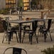 A Lancaster Table & Seating outdoor table and chairs set on a patio.