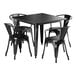 A Lancaster Table & Seating distressed onyx black metal table with four chairs.