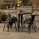 A Lancaster Table & Seating outdoor table with four black metal chairs.