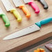 A black Choice chef knife on a wooden surface.