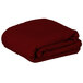 A folded rectangular burgundy fabric table cover.
