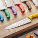 A Choice chef knife with a purple handle on a cutting board.