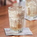 a glass of ice and liquid on a napkin