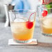 A close-up of a Pasabahce old fashioned glass with ice and a cherry.