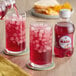 A person pouring Boylan Pomegranate Blueberry Sparkling Fruit Beverage into a glass of ice.