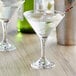 Two Pasabahce martini glasses with drinks in them.