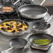 A Vigor SS1 stainless steel non-stick fry pan with asparagus cooking in it.