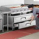 A chef using a Cooking Performance Group countertop griddle.