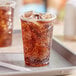 Two EcoChoice PLA compostable plastic cups filled with soda on a tray.