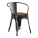 A Lancaster Table & Seating black metal arm chair with a wooden seat.