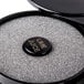 A black container with a round black sponge in it.