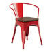 A red Lancaster Table & Seating metal arm chair with a wooden seat.