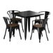 A Lancaster Table & Seating black metal table with four chairs with walnut wood seats.