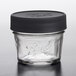 A Ball glass canning jar with a black plastic lid.