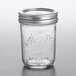 A Kerr clear glass canning jar with a silver metal lid on a table.