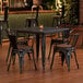 A Lancaster Table and Seating table with chairs in a restaurant dining area.
