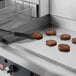 A Cooking Performance Group 36N Ultra Series 3-Burner Countertop Griddle with burgers cooking on it.