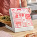 A white 12-inch square pizza box with red printed graphics and customizable design, shown being used to package a pizza.