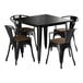 A black square Lancaster Table & Seating table with black metal chairs with walnut wood seats.