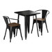 A black metal Lancaster Table & Seating square table with legs and two chairs with walnut wood seats.