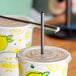 Choice jumbo black wrapped straws in cups on a table in a juice bar.