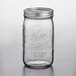 A close up of a clear Kerr wide mouth glass canning jar with a silver metal lid.