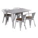 A white metal Lancaster Table & Seating table with a metal frame and walnut wood seats with legs and four chairs.