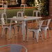 A Lancaster Table and Seating table with white legs and 4 white chairs with wooden seats.