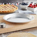 A Baker's Mark aluminum pie pan with a pie on a cutting board.