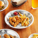 A Choice aluminum pie pan filled with a pie on a table with a plate of chicken and fries.