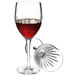 A Luigi Bormioli red wine glass filled with red wine on a table in a winery cellar.