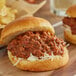 Two sloppy joe sandwiches with RedPack Sloppy Joe Sauce on a cutting board.