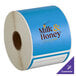 A roll of blue TamperSafe labels with white text on a white background.