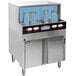 A CMA Dishmachines undercounter glass washer with bottles inside.