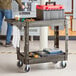 A man standing next to a black Lavex utility cart with built-in tool compartments.