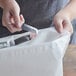 A person's hands holding a clear plastic strip and a white Seal2Go delivery bag.